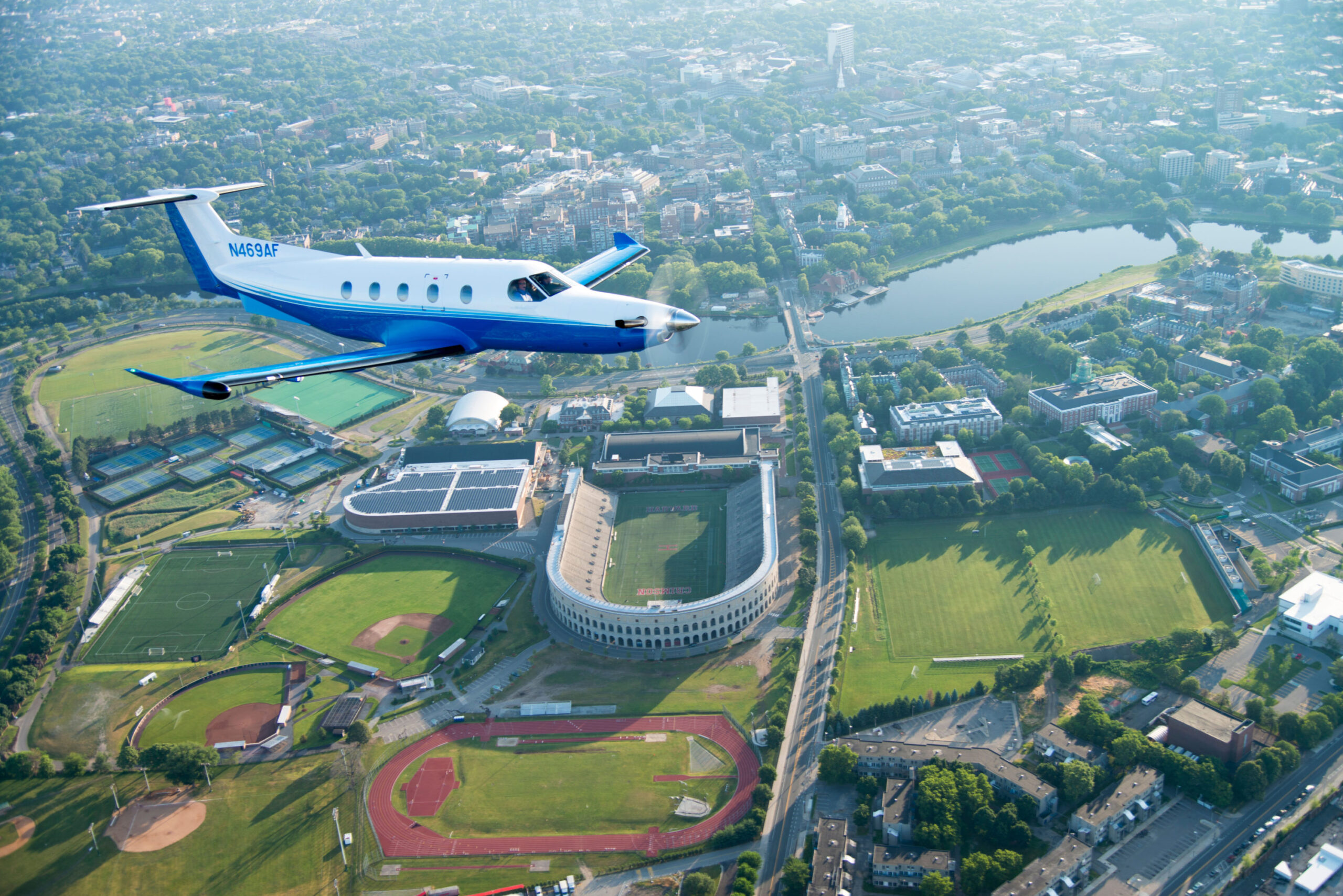 pc-12 flies over a college football stadium